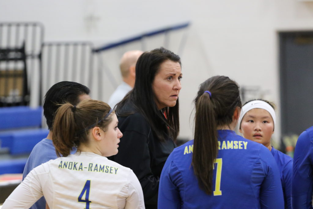 Coach Herlofsky taking a moment with the team during the volleyball season.